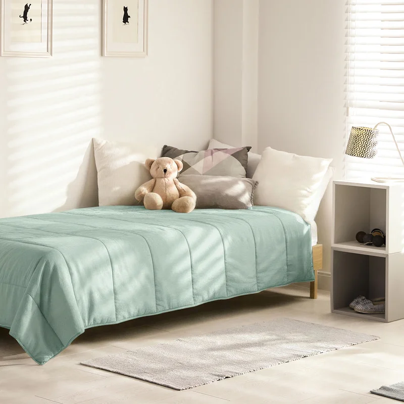 Ons Mousseline Mosgroen dekbed op een kinderbed met knuffelbeer