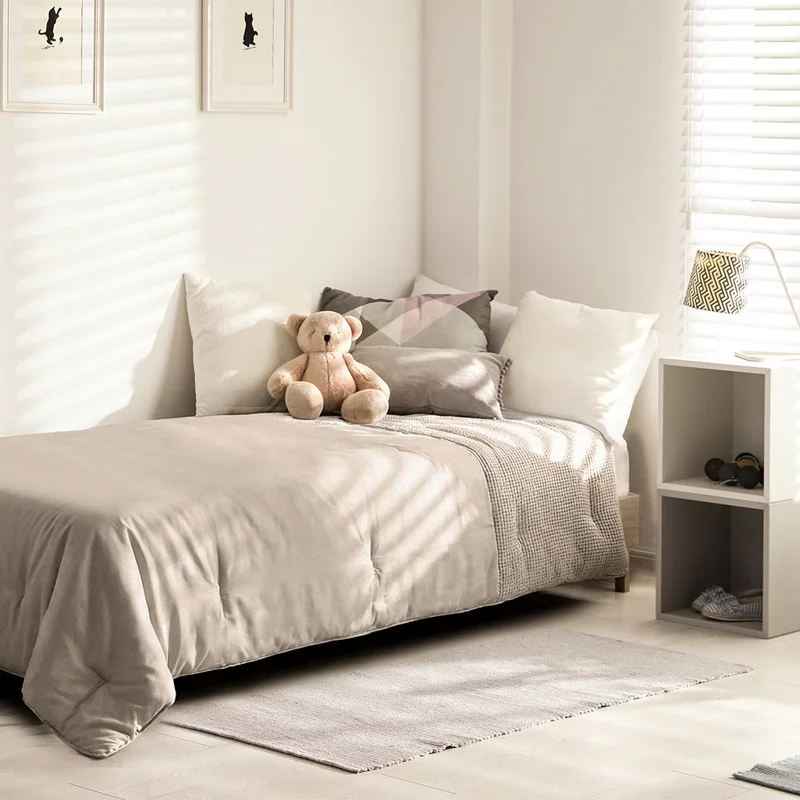 Waffle dekbed in taupe op een eenpersoonsbed in een lichte slaapkamer
